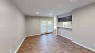 Located in Lewisville, TX, this 2-bedroom, 2-bathroom single-floor residence offers a functional and well-appointed layout. The living room features warm wood-look flooring, recessed lighting, and French doors that invite natural light and outdoor views. Adjacent to the living area, the dining room is highlighted by a stylish chandelier and large windows with outdoor views, creating a bright and welcoming space. The galley-style kitchen is efficiently designed with dark cabinetry, marble-look countertops, a stainless steel sink, and white appliances including a range, dishwasher, and refrigerator. Both bedrooms are comfortably carpeted and include ceiling fans and windows that bring in natural light. The primary bedroom offers generous proportions along with closet access. The bathrooms are finished with updated dark vanities, marble-look countertops, and clean white tub-shower combinations complemented by wood-look flooring. A dedicated closet adds convenient storage. Neutral gray tones throughout the home create a cohesive, modern aesthetic, while white six-panel doors and crisp baseboards contribute a clean, finished look across every room.
