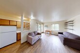 Located at 323 Packard St in Ann Arbor, Michigan, this one-bedroom, two-bathroom unit offers a practical and comfortable layout across a single floor. The open-concept living and dining area is bright and welcoming, featuring light wood-look flooring, neutral walls, and multiple windows that invite natural light and views of the surrounding greenery. A wall-mounted A/C unit and baseboard heating ensure year-round comfort. Built-in wall shelving provides functional display and storage space, while a distinctive light blue entry door adds a subtle pop of character.

The kitchen is positioned adjacent to the living area with a pass-through opening, featuring warm wood cabinetry, a full-size refrigerator, and ample counter space. A balcony extends the living space outdoors, offering a pleasant retreat.

The bedroom is a comfortable, well-proportioned room with wood-look flooring, a window overlooking mature trees, and access to generous built-in closet storage with full-height cabinetry. Recessed lighting adds a clean, modern touch. The two bathrooms include a tiled tub/shower combination with classic white square tile. A hallway and two dedicated closets further enhance storage throughout the unit, making this a well-organized and functional home.