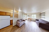 Located at 323 Packard St in Ann Arbor, Michigan, this one-bedroom, two-bathroom unit offers a practical and comfortable layout across a single floor. The open-concept living and dining area is bright and welcoming, featuring light wood-look flooring, neutral walls, and multiple windows that invite natural light and views of the surrounding greenery. A wall-mounted A/C unit and baseboard heating ensure year-round comfort. Built-in wall shelving provides functional display and storage space, while a distinctive light blue entry door adds a subtle pop of character.

The kitchen is positioned adjacent to the living area with a pass-through opening, featuring warm wood cabinetry, a full-size refrigerator, and ample counter space. A balcony extends the living space outdoors, offering a pleasant retreat.

The bedroom is a comfortable, well-proportioned room with wood-look flooring, a window overlooking mature trees, and access to generous built-in closet storage with full-height cabinetry. Recessed lighting adds a clean, modern touch. The two bathrooms include a tiled tub/shower combination with classic white square tile. A hallway and two dedicated closets further enhance storage throughout the unit, making this a well-organized and functional home.