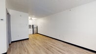 Located at 1255 S SH 6 Access Rd in Houston, TX, this single-floor unit has been thoughtfully updated to offer a clean, move-in-ready living experience. The main living area is bright and open, featuring light wood-look luxury vinyl flooring that flows consistently throughout the space. White walls and a textured ceiling create a neutral, versatile backdrop, while a wall-mounted HVAC unit ensures year-round comfort. A window with blinds allows natural light to fill the room, and a curtained closet provides convenient built-in storage.

The compact kitchen is efficiently designed and fully equipped, showcasing crisp white shaker-style cabinetry, a mosaic tile backsplash in gray tones, a stainless steel refrigerator, a built-in microwave, and a single-basin sink — all illuminated by a modern gold-accented chandelier that adds a contemporary touch.

The bathroom features a clean, all-white aesthetic with a full soaking tub and shower combination fitted with brushed nickel fixtures, complemented by wood-look flooring that ties seamlessly into the rest of the unit.

The overall ambiance is clean, minimal, and functional, making this Houston property a practical and well-appointed living space.