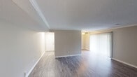 This single-floor residence offers a thoughtfully designed layout with a clean, neutral aesthetic throughout. The open living and dining areas are finished with durable wood-look flooring and warm greige walls, complemented by crown molding that adds a refined architectural touch. A textured ceiling runs throughout the common areas, while large vertical blinds on a sliding glass door allow for abundant natural light and outdoor access. A ceiling fan enhances comfort in the living space.

The galley-style kitchen is well-equipped, featuring warm honey-toned cabinetry with arched door detailing, dark granite-look countertops, white subway tile backsplash, and black appliances including a range, refrigerator, and dishwasher. A double-basin stainless steel sink completes the functional workspace.

The bedroom offers plush wall-to-wall carpeting, creating a cozy retreat, while the bathroom presents a granite-look vanity countertop, an oval undermount sink, a large mirror, and clean white tile wainscoting. A hallway connects the private spaces, maintaining a smooth and practical flow throughout the residence. The overall design is understated and move-in ready, with consistent finishes that create a cohesive and comfortable living environment.