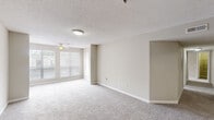 Located at 925 Gresham Ave NE in Marietta, Georgia, this single-floor, three-bedroom, two-bathroom home offers a practical and comfortable layout. The open living room is a welcoming space featuring plush wall-to-wall carpeting, neutral beige tones, a ceiling fan, and large windows that fill the room with natural light. The galley-style kitchen connects directly to the living area via a pass-through counter, and is equipped with stainless steel appliances including a range and refrigerator, white cabinetry, speckled countertops, and hardwood-style flooring. The three bedrooms are carpeted and finished in soft neutral tones, providing a calm and restful atmosphere. The primary bedroom offers generous proportions with double closets for ample storage. The bathrooms are clean and functional — one features hardwood-style flooring, a wide vanity with speckled countertops, white cabinetry, and a large mirror with overhead lighting, while the other includes a full tub-shower combination with white tile surround. A hallway connects the bedroom wing, and a dedicated closet adds extra storage. Throughout, the home maintains a cohesive, understated aesthetic with white trim, textured ceilings, and consistent neutral finishes.