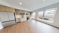 This 580-square-foot, third-floor apartment at 16849 Redmond Way in Redmond, WA offers a compact yet efficiently designed 3-bedroom, 1-bathroom layout across a single floor. Light wood-tone luxury vinyl plank flooring runs throughout, creating a cohesive and modern aesthetic.

The kitchen is a standout feature, equipped with stainless steel appliances including a French-door refrigerator, gas range, built-in microwave, and dishwasher. Two-tone cabinetry pairs gray upper cabinets with natural wood lower cabinets, complemented by a tile backsplash and recessed lighting.

The primary bedroom measures 140 square feet and features a ceiling fan and a double-door closet. Additional bedrooms offer natural light through large windows with views of the surrounding Redmond streetscape. The shared hallway includes a wall-mounted thermostat for climate control.

The bathroom features clean white walls, wood-tone flooring, a vanity with an undermount sink, and matte black hardware accents. A central hallway with a louvered utility door connects all rooms efficiently. The open-concept area adjacent to the kitchen provides flexible living space. This unit combines modern finishes with functional design in a well-located Redmond address.