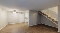 Located at 43529 Kirkland Ave in Lancaster, California, this two-story home offers a practical and well-organized layout across both levels. The main floor features an open living area with durable wood-look flooring, neutral-toned walls, and a textured ceiling. A sliding glass door fitted with vertical blinds allows natural light to fill the space while providing access to the exterior. A ceiling fan overhead aids in air circulation throughout the common area. The staircase, positioned adjacent to the living space, leads to the upper level and features carpeted treads with a white railing.

The kitchen is efficiently designed with white cabinetry extending to the ceiling, providing ample storage. Grey laminate countertops, a stainless single-basin sink, a gas range, and a full-size refrigerator complete the functional cooking space. Wood-look flooring continues through the kitchen.

Upstairs, the bedrooms are carpeted and feature vertical-blind windows that bring in natural light. Each room includes sliding-door closets offering generous storage. The bathroom is cleanly finished with wood-look tile flooring, a white vanity with a laminate countertop, a lighted mirror, and a full tub-shower combination.