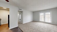 This single-story, one-bedroom, one-bathroom home offers a practical and comfortable layout designed to maximize every square foot of its modest footprint. The living room serves as the heart of the home, featuring plush wall-to-wall carpeting, neutral gray walls, and a textured ceiling. A standout feature is the set of French doors that flood the space with natural light and provide outdoor access. Dark hardwood-style flooring at the entryway creates a clean transition into the carpeted living area. The galley-style kitchen is efficiently designed with cabinetry on both sides, granite-style countertops, a mosaic tile backsplash, black appliances including a refrigerator and electric range, and hardwood-style flooring that ties the space together with a warm, cohesive feel. The bedroom offers a comfortable retreat with soft carpeting, a natural light-filled window with blinds, and two closets providing ample storage. The full bathroom is clean and functional, featuring a tub-shower combo, wood-style flooring, and a vanity with granite-style countertops. A connecting hallway links the rooms seamlessly, completing the efficient and livable floor plan of this cozy home.