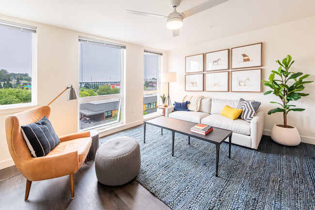 Sala de estar con ventanas del piso al techo, ventilador de techo y diseño espacioso - Muir