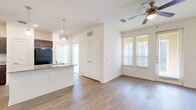 This 1-bedroom, 1-bathroom unit in Austin, TX offers a functional and thoughtfully designed single-floor layout. The open-concept living, dining, and kitchen area forms the heart of the home, unified by wood-style plank flooring and bathed in natural light from multiple windows with blinds. A ceiling fan with a light fixture adds comfort to the living area, which also features a set of double doors for added storage.

The kitchen is a standout feature, showcasing rich dark-wood cabinetry with sleek hardware, granite-style countertops, and black appliances including a range, over-the-range microwave, and refrigerator. A peninsula with an undermount sink and pendant lighting overhead provides both workspace and a casual dining option. The adjacent dining area benefits from large windows and a glass-panel door that invites natural light.

The bedroom is generously sized with plush carpeting, a ceiling fan, dual windows overlooking the exterior, and a walk-in closet with built-in shelving for ample storage. The bathroom features wood-style flooring, a dark-wood vanity, a full tub-shower combination with white tile surround, and a frosted window for natural light. Throughout, the unit maintains a clean, neutral palette that creates a bright and welcoming atmosphere.