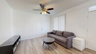Located at 1130 E Orange St in Tempe, Arizona, this two-bedroom, two-bathroom single-story unit offers a clean, modern design with a consistent aesthetic throughout. Light wood-style flooring runs across the entire space, creating a bright and cohesive look in every room.

The combined living and dining area serves as the heart of the unit, featuring a ceiling fan with light fixture, vertical blinds allowing natural light, and a shiplap-style accent wall that adds subtle texture. The open layout provides a comfortable and functional common space.

The kitchen is appointed with white cabinetry, light countertops, a stainless steel sink, and a full-size refrigerator. A pendant chandelier illuminates the adjacent dining area, which is defined by a white subway tile accent wall, tying the two spaces together seamlessly.

Both bedrooms are well-proportioned, each featuring ceiling fans, white painted brick accent walls, and ample natural light. The spacious primary bedroom comfortably accommodates a work area alongside sleeping space. Multiple closets throughout the unit offer generous storage.

The two bathrooms maintain the home's clean, minimal theme — one features a tub-shower combo with a curtain, while the other includes a glass-door shower enclosure with brushed hardware. The overall ambiance is bright, airy, and move-in ready.
