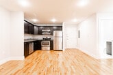 Located at 134 Sussex Ave in Newark, NJ, this thoughtfully designed single-floor residence offers a clean, modern aesthetic with consistent hardwood flooring flowing throughout the living spaces. The open layout connects the living area to the kitchen, creating a functional and welcoming atmosphere filled with recessed lighting.

The kitchen is a standout feature, outfitted with dark espresso shaker-style cabinetry, granite countertops, and a full suite of stainless steel appliances including a refrigerator, electric range, microwave, and dishwasher. Ample cabinet storage and a well-organized L-shaped layout make this kitchen both practical and visually striking.

The hallway connects the various rooms with ease, featuring panel-style white doors and neutral gray walls that complement the warm tones of the hardwood floors. The bedroom spaces are bright and simply finished, offering a versatile canvas for personalization.

The bathroom is outfitted with large-format marble-look tile flooring, a full soaking tub with shower, and an all-white finish that gives the space a crisp, clean feel. Throughout the unit, white baseboards and neutral wall tones create a cohesive and polished interior. The recessed lighting ensures each room is well-lit, enhancing the overall sense of brightness and space.