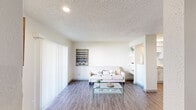 Located at 12121 Audelia Rd in Dallas, TX, this single-story one-bedroom, one-bathroom unit offers a well-organized and efficiently designed layout. The combined kitchen and living room serves as the heart of the home, featuring wood-style plank flooring, a textured ceiling, and a white fireplace that anchors the living area. Sliding glass doors with vertical blinds allow natural light to fill the space and provide an outdoor view. Built-in shelving adds a functional and decorative touch to the living room. The kitchen is outfitted with crisp white shaker-style cabinetry, granite countertops, a tile backsplash, a stainless steel sink, and a dishwasher, along with an adjacent pantry for additional storage. The bedroom is a comfortable, well-lit retreat with a ceiling fan, a window with blinds, and direct access to the bathroom. The bathroom features a granite-topped vanity with dual mirrors, white cabinetry, and a layout that connects conveniently to both the bedroom and kitchen areas. A dedicated closet and hallway complete the floorplan, ensuring practical use of every square foot in this thoughtfully updated Dallas residence.