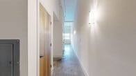 Located at 120 Perry St in Petersburg, VA, this one-bedroom, one-bathroom loft-style unit offers a thoughtfully laid-out single-floor plan with an industrial-modern aesthetic. Polished concrete floors run throughout the entire space, lending a sleek, contemporary feel that ties each room together cohesively.

The open-concept kitchen and living area forms the heart of the unit. The well-appointed kitchen features warm maple cabinetry extending to the ceiling, dark granite countertops, a kitchen island, recessed lighting, black appliances including a range and French door refrigerator, and exposed ductwork overhead that reinforces the loft character of the space.

The living area is bright and airy, highlighted by a wide horizontal window that frames outdoor views, a ceiling fan, and a rail lighting system overhead. The spacious bedroom benefits from soaring ceilings, a natural wood door, and direct access to a hallway lined with wall sconces.

The bathroom is clean and functional, featuring a maple vanity with dark granite countertop, a framed mirror, and a full soaking tub with shower. Two closets provide ample storage, including one with wire shelving. A dedicated laundry room with washer and dryer hookups adds everyday convenience to this well-designed urban residence.
