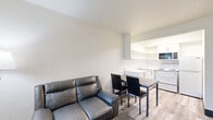 Located at 16410 North Fwy in Houston, TX, this efficiently designed one-bedroom, one-bathroom unit offers a practical and functional layout across a single floor. Light wood-look flooring runs throughout, lending a clean and cohesive aesthetic to the space.

The living room serves as the main gathering area, featuring a leather loveseat, a coffee table, and a floor lamp. Natural light enters through a window fitted with vertical blinds, while a wall-unit HVAC system ensures year-round climate comfort. The living area flows seamlessly into a compact dining nook with a small table and chairs, positioned adjacent to the kitchen.

The kitchen is efficiently arranged in an L-shape, outfitted with white cabinetry, a stainless steel sink, an electric range, an over-the-range microwave, and a full-size refrigerator — providing all essential appliances within a tidy footprint.

The bedroom is a comfortable, well-defined retreat highlighted by a bold blue accent wall that adds a vibrant focal point to the room. It includes a full-size bed frame with headboard, a dresser, and a window with vertical blinds that allows natural light to filter in.

The bathroom features tile flooring, a granite-style countertop vanity with an undermount sink, a large mirror with a medicine cabinet, and classic white fixtures, creating a clean and functional space.
