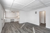 Located in the heart of Los Angeles' East Hollywood neighborhood, this single-story residence at 1014 N Oxford offers a thoughtfully updated interior with a clean, modern aesthetic throughout. The living area is a standout, featuring a distinctive coffered ceiling with beadboard detailing, crisp white walls, and wide-plank luxury vinyl flooring that runs seamlessly through the space. Large windows invite generous natural light, casting bright, airy tones across the open layout.

The kitchen is well-appointed with white shaker-style cabinetry, quartz countertops, a double-basin stainless steel sink, classic subway tile backsplash with decorative accent trim, and gold-toned hardware and track lighting that add a warm, contemporary touch. Ample upper and lower cabinet storage makes this a highly functional space.

The bedrooms each feature ceiling fans, textured ceilings, and the same durable vinyl plank flooring. One bedroom includes a built-in desk nook and a window framing views of lush greenery, while another offers a sliding-door closet with built-in rod storage. The bathrooms include a tiled shower stall with sliding glass doors and a second bath featuring a soaking tub with a frameless glass enclosure and large-format tile surround. The home presents a cohesive, move-in-ready environment with practical finishes throughout.