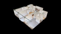 Located at 201 8th Avenue Northwest in Austin, MN, this modern single-floor apartment offers 1,030 square feet of thoughtfully designed living space across 2 bedrooms and 2 bathrooms. The open-concept kitchen and living area serves as the heart of the unit, featuring light hardwood-style flooring, rich medium-toned wood cabinetry, stainless steel appliances, and a center island with a striking white quartz countertop. The living area extends to a private balcony through sliding glass doors, filling the space with natural light and offering views of the surrounding neighborhood. Exposed ductwork adds an industrial-modern aesthetic to the main living areas. The primary bedroom measures 200 square feet and is finished with plush carpeting, while the second bedroom mirrors the same clean, neutral design. Both bedrooms are served by well-appointed bathrooms featuring warm wood vanities, white quartz countertops, undermount sinks with matte black fixtures, large rectangular mirrors, and light hardwood-style tile flooring. One bathroom includes a window for natural light. Each bedroom is complemented by a dedicated closet. Crisp white walls and consistent modern finishes give this apartment a clean, move-in-ready feel throughout.