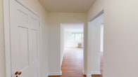 Located at 841 Highland Ave in Jenkintown, PA, this 2-bedroom, 1-bathroom residence offers a well-organized single-floor layout with a clean, classic aesthetic throughout. Warm-toned hardwood floors run consistently through the living spaces, lending a sense of continuity and character to the home. The hallways connect the rooms seamlessly, providing an open and accessible flow.

The living room is bright and inviting, featuring large windows that frame views of surrounding trees and greenery, along with a cast-iron radiator that adds classic charm. Both bedrooms are comfortably sized, each equipped with ceiling fans and large windows that admit generous natural light. The primary bedroom includes a closet and connects easily to the hallway corridor. Radiator heating units are present in both bedrooms.

The kitchen is efficiently designed with white cabinetry, subway tile backsplash, granite-look countertops, and white appliances including a gas range, dishwasher, microwave, and refrigerator. Wood-look flooring grounds the kitchen space, and a window unit provides additional climate control.

The bathroom features a full tub-shower combination with white tile surround and classic dark accent trim. Throughout the home, neutral walls and consistent finishes create a bright, functional living environment.