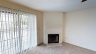 Located at 200 Fox Gate Ave in Hattiesburg, Mississippi, this single-floor residence offers a comfortable and functional layout throughout. The living room serves as the heart of the home, highlighted by a wood-burning fireplace with a classic white mantel and tile surround, plush carpeting, and a large sliding glass door fitted with vertical blinds that allows natural light to fill the space and provides access to the outdoors. A ceiling fan adds to the room's comfort and airflow.

The living area opens toward a galley-style kitchen, which is efficiently arranged with white cabinetry, wood-trimmed cabinet doors, white appliances including a refrigerator and electric range, a double-basin stainless steel sink, and durable wood-look flooring. A peninsula counter connects the kitchen to the main living space, creating a convenient pass-through area.

The bedrooms are carpeted and well-proportioned, each equipped with ceiling fans and ample natural light from windows with blinds. The rooms feature clean, neutral walls and panel-style doors, offering a versatile canvas for any living arrangement.

The bathroom is thoughtfully laid out with a single-sink vanity, a full-sized tub and shower combo, wood-look flooring, and built-in storage cabinetry. Textured ceilings are present throughout the home, contributing to its classic residential character.