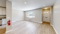 This well-appointed one-bedroom, one-bathroom unit at 70 Mitchell Rd in Hackettstown, NJ offers a thoughtfully designed single-floor layout that maximizes every square foot. The open-concept living and kitchen area is anchored by light hardwood flooring that flows throughout, recessed lighting, and large windows that invite natural light and outdoor views. A wall-unit air conditioner and baseboard heating ensure year-round comfort.

The kitchen is a standout feature, equipped with white shaker-style cabinetry reaching toward the ceiling for generous storage, granite-look countertops, a stainless steel refrigerator, gas range, microwave, and dishwasher. A breakfast bar peninsula connects the kitchen to the living area, enhancing the open feel.

The bedroom is carpeted for comfort and features a ceiling fan with light, a bright window with blinds, and a dedicated closet. The bathroom is finished with large-format tile surrounding a soaking tub and rain showerhead, paired with chrome fixtures for a clean, modern aesthetic.

The unit is completed by a private entry door and a neutral color palette throughout, creating a bright and move-in-ready living environment in a convenient Hackettstown location.
