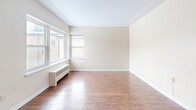 Located at 571 Adelaide St N in London, Ontario, this 2-bedroom, 1-bathroom unit offers a practical and comfortable single-floor layout. The entrance leads into a well-organized hallway featuring light tile flooring and multiple closets, providing generous storage from the moment you step inside.

The combined living and dining area is a standout feature, offering an open, airy feel with warm hardwood-style flooring that flows throughout the main living spaces. Natural light fills the room through large windows, complemented by radiator heating units along the walls. The textured ceiling adds a classic character to the space.

The kitchen is efficiently designed with white cabinetry, a double-basin sink, white appliances including a stove and refrigerator, and light tile flooring. A window above the counter allows for additional natural light.

Both bedrooms feature the same warm hardwood-style floors, radiator heating, and windows overlooking the outdoors. The primary bedroom includes a dedicated closet, while a ceiling fan adds comfort. The second bedroom also benefits from its own closet access.

The bathroom is clean and functional, finished with tile flooring and tile surround in the tub/shower area, a vanity with under-sink storage, and a mirror above.