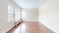 Located at 571 Adelaide St N in London, Ontario, this 2-bedroom, 1-bathroom unit offers a practical and comfortable single-floor layout. The entrance leads into a well-organized hallway featuring light tile flooring and multiple closets, providing generous storage from the moment you step inside.

The combined living and dining area is a standout feature, offering an open, airy feel with warm hardwood-style flooring that flows throughout the main living spaces. Natural light fills the room through large windows, complemented by radiator heating units along the walls. The textured ceiling adds a classic character to the space.

The kitchen is efficiently designed with white cabinetry, a double-basin sink, white appliances including a stove and refrigerator, and light tile flooring. A window above the counter allows for additional natural light.

Both bedrooms feature the same warm hardwood-style floors, radiator heating, and windows overlooking the outdoors. The primary bedroom includes a dedicated closet, while a ceiling fan adds comfort. The second bedroom also benefits from its own closet access.

The bathroom is clean and functional, finished with tile flooring and tile surround in the tub/shower area, a vanity with under-sink storage, and a mirror above.