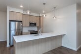 Located at 13450 W Baldcypress St in Boise, Idaho, this single-floor 3-bedroom, 2-bathroom residence offers a thoughtfully designed open-concept layout with modern finishes throughout. The heart of the home is a stylish kitchen featuring a generous island with a white quartz countertop, undermount sink, and sleek pendant lighting. Light wood cabinetry pairs beautifully with a subway tile backsplash, and the kitchen is fully equipped with stainless steel appliances including a refrigerator, range, microwave, and dishwasher. The kitchen flows seamlessly into a spacious living area finished with warm wood-tone luxury vinyl plank flooring, recessed lighting, and a wall-mounted mini-split unit. A glass-paneled door leads to an outdoor area, filling the living space with natural light. The bedrooms are carpeted and generously sized, with large windows that frame outdoor views and allow ample daylight. One bedroom includes a walk-in closet and built-in shelving. Both bathrooms are clean and functional — the primary bath features a wide vanity with quartz countertop and a full tub/shower, while the secondary bath offers a tiled tub/shower combo with wood-look flooring. The overall aesthetic is clean, contemporary, and move-in ready.