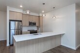 Located at 13450 W Baldcypress St in Boise, Idaho, this single-floor 3-bedroom, 2-bathroom residence offers a thoughtfully designed open-concept layout with modern finishes throughout. The heart of the home is a stylish kitchen featuring a generous island with a white quartz countertop, undermount sink, and sleek pendant lighting. Light wood cabinetry pairs beautifully with a subway tile backsplash, and the kitchen is fully equipped with stainless steel appliances including a refrigerator, range, microwave, and dishwasher. The kitchen flows seamlessly into a spacious living area finished with warm wood-tone luxury vinyl plank flooring, recessed lighting, and a wall-mounted mini-split unit. A glass-paneled door leads to an outdoor area, filling the living space with natural light. The bedrooms are carpeted and generously sized, with large windows that frame outdoor views and allow ample daylight. One bedroom includes a walk-in closet and built-in shelving. Both bathrooms are clean and functional — the primary bath features a wide vanity with quartz countertop and a full tub/shower, while the secondary bath offers a tiled tub/shower combo with wood-look flooring. The overall aesthetic is clean, contemporary, and move-in ready.