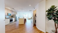 Located in the heart of downtown Phoenix, this thoughtfully designed one-bedroom, two-bathroom residence offers a bright and open-concept living experience. Warm hardwood-style flooring flows throughout, complementing the clean white walls and modern finishes that define the space. The open living, dining, and kitchen area is anchored by floor-to-ceiling windows that flood the interior with natural light and frame stunning views of the Phoenix skyline. The well-appointed kitchen features stainless steel appliances, a gas range, quartz countertops, a marble-style tile backsplash, and a mix of white lower cabinets and light wood upper cabinetry, with a center island offering bar seating. The dining area sits adjacent to a large picture window showcasing panoramic city views. The spacious living room benefits from wraparound glazing, creating an airy, light-filled atmosphere. The generously sized primary bedroom includes a large window with city views and access to a walk-in closet with built-in shelving. Two clean, modern bathrooms and an in-unit stacked washer and dryer add everyday convenience. This residence offers an exceptional urban living experience in one of Phoenix's most vibrant downtown locations.