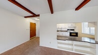 Located at 28 Bard Dr in Hudson, Ohio, this one-bedroom, one-bathroom unit offers a well-organized single-floor layout with a comfortable and functional design. The living room is a standout space, characterized by rich, dark wood exposed ceiling beams that add architectural character. Plush wall-to-wall carpeting runs underfoot, and a large sliding glass door floods the room with natural light while providing direct access to an outdoor patio with views of surrounding greenery. A wall-mounted A/C unit and baseboard heating ensure year-round comfort.

The kitchen is thoughtfully open to the living area via a pass-through counter with granite-style countertops, creating a connected feel. White cabinetry offers ample storage, complemented by a full suite of appliances including a refrigerator, electric range, and oven. The kitchen also features a window for natural light.

The bedroom is a well-proportioned retreat with carpet flooring, a ceiling fan, a window with outdoor views, and a wide double sliding-door closet with dual hanging rods for generous storage.

The bathroom includes white subway tile wainscoting, a combined tub and shower, a wood-toned vanity, and hardwood-style flooring, completing this efficient and practical Hudson residence.