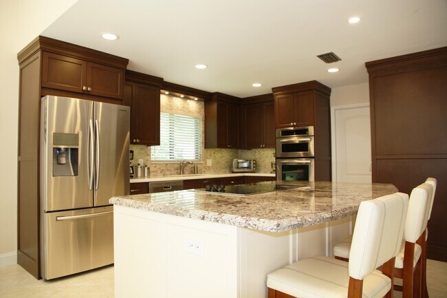 Cocina bellamente renovada con gabinetes de madera. - 2662 NW 42nd St
