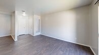 Located at 517 N Loop 288 in Denton, TX, this single-floor, 2-bedroom, 2-bathroom unit offers a practical and comfortable layout with thoughtful finishes throughout. The living room makes a strong first impression with rich, dark hardwood-style flooring, neutral gray walls, and a sliding glass door that opens to a private balcony overlooking a community pool area, filling the space with natural light and outdoor views. The galley-style kitchen is efficiently designed with warm wooden cabinetry, gray laminate countertops, a stainless steel double sink, and black appliances including a refrigerator, range, and dishwasher, all set atop matching hardwood-style flooring. Both bedrooms are carpeted for comfort and each features a ceiling fan with light fixture. The primary bedroom offers a well-sized layout, while the secondary bedroom includes a closet and a window with natural light. The two bathrooms are clean and functional — one features a full tiled tub-and-shower combination with chrome fixtures, while the other includes a white vanity, mirror, and dark hardwood-style flooring. A hallway connects the rooms, rounding out a cohesive and move-in-ready floor plan.