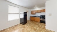 Located at 5504-5512 S Wabash Ave in Chicago's South Side, this 2-bedroom, 1-bathroom unit offers a practical and straightforward layout across a single floor. The kitchen is equipped with warm wood cabinetry, dark countertops, a black gas range, and a stainless steel refrigerator, with durable tile flooring and a window that brings in natural light. The living and kitchen areas feature easy-to-maintain tile flooring, while both bedrooms are fitted with wall-to-wall carpet for added comfort. The primary bedroom is a well-proportioned space that includes a classic cast-iron radiator, a closet, and a window, with an adjacent pass-through to the second bedroom. The second bedroom is bright and cozy, also carpeted and naturally lit by a window with blinds. The full bathroom includes a tub/shower combo with full tile surround, a vanity with sink, and a privacy window. Throughout the unit, clean white walls, flush-mount lighting, and consistent finishes create a simple, uniform aesthetic. The space provides functional, no-frills living in a well-established Chicago neighborhood.