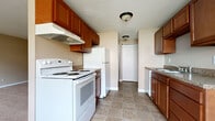 Located at 2660 Chili Ave in Rochester, NY, this one-bedroom, one-bathroom unit offers a practical and well-organized single-floor layout. The galley-style kitchen is efficiently designed with warm wood cabinetry lining both walls, granite-look countertops, a double sink, and white appliances including an electric range and refrigerator. Tile flooring in a neutral stone pattern runs throughout the kitchen and dining area, which is brightened by a large window and ceiling fan, creating a comfortable everyday space.

The living area flows naturally from the kitchen, featuring soft carpeting underfoot, warm beige walls, and white baseboard trim. It is a generously proportioned open space well-suited for both relaxing and entertaining. The bedroom offers a comfortable footprint with plush carpeting, a large window that allows ample natural light, a sliding-door closet, and baseboard heating. An additional closet provides extra storage convenience.

The bathroom includes a full-size soaking tub, a vanity with under-sink cabinet storage, and tile flooring. Throughout the unit, neutral tones and clean finishes create a cohesive, move-in-ready atmosphere. Baseboard heating is present in multiple rooms, ensuring reliable warmth during Rochester's colder months.