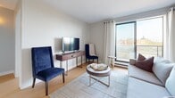 Located at 1400 Ouellette Ave in Windsor, Ontario, this well-designed one-bedroom, one-bathroom unit offers a smart and functional layout across a single floor. The living room serves as the heart of the space, featuring warm light hardwood flooring, neutral wall tones, and a large window with sheer white curtains that frame open city views, filling the room with natural light. The kitchen is outfitted with white cabinetry, tile backsplash, and a stainless sink, providing a clean and practical workspace. The bedroom is a calm retreat with a built-in sliding-door wardrobe offering ample storage, complemented by a window that brings in natural light and overlooks the surrounding Windsor cityscape. The bathroom is finished in classic white tile, featuring a full-size soaking tub with a shower and curtain, maintaining a clean and functional aesthetic throughout. Light hardwood flooring flows consistently through the main living areas, tying the space together with a cohesive warmth. Neutral tones across every room create a versatile and welcoming atmosphere, well-suited for comfortable urban living in the heart of Windsor.