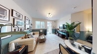 This thoughtfully designed single-floor residence blends contemporary style with warm, inviting details throughout. A striking teal half-wall accent carries cohesively from the living room through the bedroom, creating a bold yet harmonious design thread across the space.

The living area is bright and welcoming, with light pouring in through slatted blinds and a glass door that opens to an outdoor area. Light hardwood flooring runs throughout, complementing the crisp white upper walls. A wall-mounted flat-screen TV sits above a built-in floating media shelf, while curated framed artwork adorns the walls, adding personality and depth.

The kitchen is efficiently laid out with warm wood cabinetry, open shelving, white tile backsplash, light countertops, and a full suite of stainless steel appliances including a gas range, microwave, refrigerator, and dishwasher. An in-unit washer and dryer are conveniently tucked nearby.

The bedroom continues the teal accent wall motif, offering a calm and restful atmosphere accented by lush indoor plants and soft lighting. A full-length mirror and thoughtful décor complete the space.

The bathroom is finished with floor-to-ceiling marble-look tile, a tub-shower combination with glass sliding doors, a wood vanity with white countertop, and a large mirror — offering a clean, spa-like aesthetic throughout.