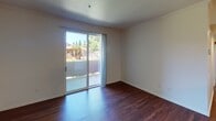 Located at 8000 Painted Desert Dr in Roseville, California, this single-floor apartment offers a practical and comfortable layout with a clean, neutral aesthetic throughout. Rich hardwood flooring runs through the main living areas, lending warmth and a polished look to the space.

The kitchen is thoughtfully designed with ample white cabinetry trimmed in wood tones, generous counter space, a full suite of appliances including a coil-burner range and refrigerator, and a pass-through counter that opens to the dining area. The dining space is bright and airy, highlighted by a pendant light overhead and a seamless connection to the kitchen.

The living area features sliding glass doors that open to an outdoor patio, flooding the room with natural light and offering views of the surrounding neighborhood greenery. The bedrooms are carpeted for comfort and each includes large double-hung windows that frame pleasant outdoor views of landscaped grounds and mature trees.

Two bathrooms serve the unit — one features a tub and shower combination with wood-tone hardwood flooring, while the other includes a tub-shower enclosure with gold-framed sliding glass doors. Both bathrooms are finished in clean, light tones. Overall, the apartment presents a straightforward, well-maintained living environment in a residential Roseville community.