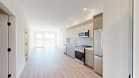 Located at 988 S Manhattan Pl in Los Angeles, CA, this modern 3-bedroom, 3-bathroom unit offers a well-designed open-concept layout with contemporary finishes throughout. Light wood-tone flooring flows consistently across the entire space, creating a cohesive and airy aesthetic.

The combined kitchen and living area serves as the heart of the unit. The kitchen is outfitted with flat-front cabinetry in a warm wood finish, a subway-tile backsplash, light quartz countertops, a single-basin undermount sink, and a full suite of stainless steel appliances including a range, built-in microwave, dishwasher, and refrigerator. The open living area extends naturally from the kitchen, filled with natural light from large sliding glass doors that lead to a private balcony overlooking the surrounding Los Angeles neighborhood.

Each of the three bedrooms features clean white walls, recessed lighting, and ample natural light. Select bedrooms include large windows or sliding glass doors with views of the cityscape and palm tree-lined streets. Each bedroom is accompanied by a dedicated closet, with built-in shelving providing practical storage. The three bathrooms are finished with neutral large-format tile flooring and floor-to-ceiling stacked tile surrounds in the tub-shower combinations, maintaining a consistent modern aesthetic throughout.