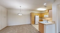 This two-story home offers a thoughtfully designed layout across two floors, providing comfortable living with two bedrooms, two full bathrooms, and generous storage throughout. The main living level is anchored by a well-appointed kitchen featuring warm honey-toned wood cabinetry, light stone countertops, a full suite of white appliances including a refrigerator, range, microwave, and dishwasher, and classic tile flooring. A pendant light fixture highlights the open connection between the kitchen and the adjoining carpeted living area, creating a welcoming, cohesive space. Carpeted stairs with a handrail lead to the upper level, where the primary bedroom offers a ceiling fan, a wide closet, and direct access to an en suite bathroom. The second bedroom is equally inviting, featuring vaulted ceilings, a ceiling fan, natural light from a window, and soft carpeting. Both bathrooms are finished with tile flooring, vanities with warm wood cabinetry, and tub-shower combinations enclosed by sliding frosted glass doors. A striking vaulted upper hallway with recessed lighting adds architectural character to the upper floor. Additional highlights include multiple closets, two hallways for easy circulation, and a balcony for outdoor enjoyment.