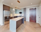 This impressive 1080 square foot penthouse apartment, located at 1 Canal St in Boston, offers a perfect blend of luxury and functionality. The space boasts two bedrooms, including a spacious 220 square foot primary bedroom, and two well-appointed bathrooms. The open-concept living area is characterized by its abundance of natural light, courtesy of floor-to-ceiling windows that frame breathtaking city views.

The gourmet kitchen is a culinary enthusiast's dream, featuring sleek cabinetry, high-end stainless steel appliances, and a large island with a waterfall countertop. The living room flows seamlessly from the kitchen, creating an ideal space for entertaining or relaxing.

Throughout the apartment, you'll find premium finishes including hardwood floors in a stylish herringbone pattern, recessed lighting, and contemporary fixtures. The bathrooms are modern and elegant, with one featuring a glass-enclosed shower and separate bathtub.

A private balcony offers an outdoor retreat with panoramic views of Boston's skyline. The convenience of in-unit laundry adds to the apartment's appeal. This penthouse combines luxurious amenities with a prime downtown location, making it a truly exceptional urban dwelling.