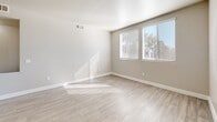 Located at 7413 W Russell Rd in Las Vegas, NV, this well-appointed one-bedroom, one-bathroom unit offers a thoughtfully designed single-floor layout. The open-concept kitchen and living area serves as the heart of the home, featuring light wood-style flooring, neutral tones, and ample natural light streaming through multiple windows. The kitchen is equipped with stainless steel appliances — including a gas range, microwave, and refrigerator — white cabinetry, a mosaic tile backsplash, and a peninsula with a double-basin sink that overlooks the living area. A ceiling fan adds comfort to the living space, which also benefits from a large sliding window with outdoor views. The generously sized bedroom is finished with plush carpet, a ceiling fan, and windows that allow natural light to fill the room. The full bathroom features a white vanity with under-cabinet storage, a large mirror, and a tub/shower combination. A dedicated in-unit laundry area houses a full-size washer and dryer with overhead shelving. The unit also includes a closet, completing this efficient and comfortable living space in the heart of Las Vegas.