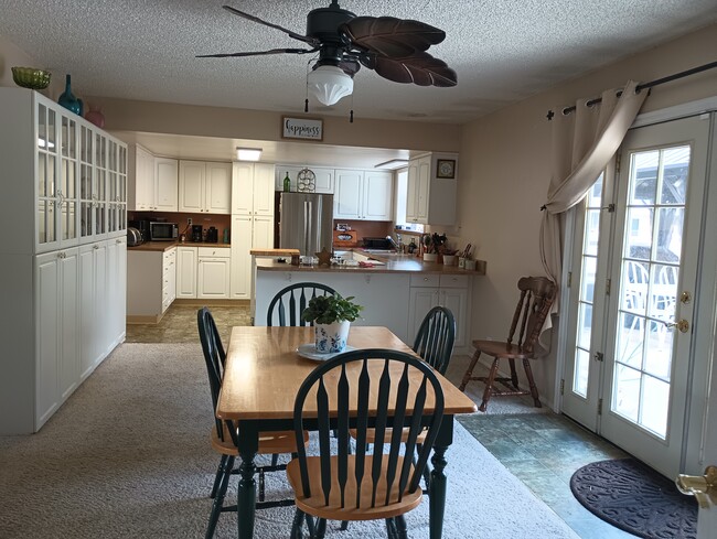 Open concept kitchen with chrome appliances, dining room with built-in hutch and French doors out to - 1574 Collins Rd