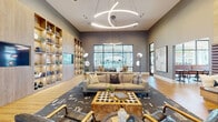 This single-story clubhouse in Memphis, Tennessee, showcases a thoughtfully curated contemporary design that balances sophistication with comfort. The space is characterized by soaring ceilings that lend an expansive, airy feel throughout, complemented by warm hardwood-style flooring that runs continuously across the main areas.

The central lounge serves as the heart of the clubhouse, anchored by a striking sculptural LED chandelier with sweeping circular forms that draw the eye upward. A floor-to-ceiling built-in shelving wall in natural wood tones houses decorative accents and an integrated flat-screen television, creating a refined focal point. Seating arrangements include a neutral sectional sofa, leather accent chairs, and a live-edge wood coffee table set atop a bold geometric area rug, fostering an inviting gathering atmosphere.

Large black-framed windows and glass doors allow abundant natural light to filter in while offering views of the outdoor surroundings. A built-in upholstered bench with tufted leather-style paneling provides a cozy nook alongside open shelving.

A separate office or leasing area is enclosed by floor-to-ceiling black-framed glass partitions, furnished with vibrant orange accent seating and a textured feature wall, maintaining visual connectivity while defining distinct functional zones. The overall ambiance is modern, welcoming, and refined.