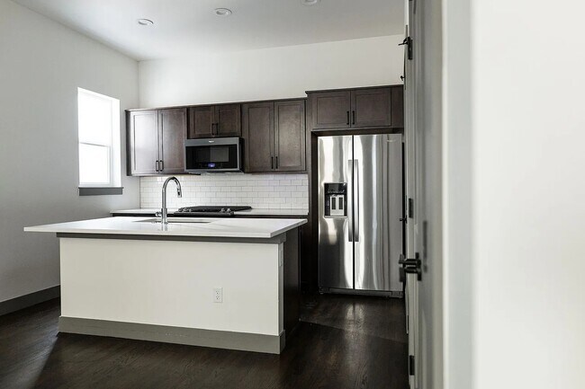 Cocina completa con electrodomésticos de acero inoxidable, que incluyen microondas, cocina a gas, lavavajillas y refrigerador. - 3505 S Marion St