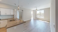 Located at 16101 Murphy Ave in Irvine, CA, this single-floor unit offers a clean, modern aesthetic throughout its well-designed layout. The open-concept living and dining area is bathed in natural light from large windows and features light wood-tone flooring, neutral warm-gray walls, and a ceiling fan, creating a bright and airy atmosphere. The space flows seamlessly into the kitchen, which is equipped with stainless steel appliances including a gas range, built-in microwave, and french door refrigerator. White shaker cabinetry, a dark countertop with a peninsula, and pendant lighting above the kitchen bar add both style and functionality.

The bedrooms are carpeted for comfort, each featuring ceiling fans and windows that invite natural light and outdoor views. The primary bathroom offers a full tub-and-shower combo with sliding glass doors, open shelving, a white vanity with dark countertop, and an LED-backlit mirror. A second bathroom mirrors the same refined design with a single-sink vanity, open shelving, and light wood-look tile flooring. Recessed lighting, consistent neutral tones, and thoughtful storage solutions throughout the space contribute to a cohesive and move-in-ready interior ideal for modern living in Irvine.