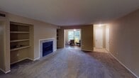 Located at 7825 Calibre Crossing Dr in Charlotte, NC, this single-floor residence offers a thoughtfully arranged layout with a warm, neutral color palette throughout. The main living area is anchored by a tile-surround fireplace flanked by built-in shelving, providing both a functional focal point and additional storage. Plush carpeting flows through the living spaces, while durable wood-look flooring extends through the kitchen, dining, and wet areas. A defined dining space sits adjacent to the living room, illuminated by a brushed nickel pendant light. The galley-style kitchen is equipped with white shaker cabinetry, light quartz-style countertops, a subway tile backsplash, stainless steel sink, and gas range. A dedicated in-unit laundry closet with side-by-side washer and dryer hookups is conveniently accessible directly from the kitchen. The primary bedroom features a sliding glass door that opens to a private outdoor area, along with a spacious walk-in closet. Additional bedrooms offer ample room and closet space. The bathroom includes a single-sink vanity with generous counter space, a large mirror, and a full tub-shower combination. A tiled entryway completes the home's functional and cohesive design.