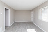 Located at 3345 Chamblee Tucker Rd in Atlanta, Georgia, this single-floor unit offers a practical and well-organized layout throughout. The kitchen is equipped with white cabinetry, light-toned countertops, a stainless steel sink, a white dishwasher, and a black electric range with overhead ventilation — providing ample storage and workspace for everyday cooking needs. The living area is open and airy, featuring durable wood-look flooring, neutral taupe walls, crisp white baseboards, and a window fitted with horizontal blinds that allows natural light to fill the space. A classic six-panel white entry door adds a clean, traditional touch to the room. The bedroom continues the neutral color palette and offers plush carpeting underfoot, a built-in closet with sliding doors, and a flush-mount ceiling light fixture. The bathroom is neatly appointed with wood-look flooring, a white vanity with under-sink storage, a large mirror, tile surround, and a full shower-tub combination. Throughout the unit, the consistent use of warm neutral tones, light flooring, and white trim elements creates a cohesive and inviting atmosphere well-suited for comfortable everyday living.