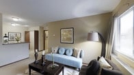 Located at 300 Springboro Lane in Columbus, Ohio, this single-floor residence offers a thoughtfully designed living environment with a warm and inviting atmosphere. The living area serves as the centerpiece of the home, featuring neutral-toned walls that create a calm, cohesive backdrop throughout the space. Smooth ceilings add to the open, airy feel of the room, while the layout allows for easy flow between areas. The living room is generously sized, providing ample space for comfortable seating arrangements and stylish décor. A hallway connects the main living area to additional rooms, hinting at a functional and well-organized floor plan. Natural and ambient lighting work in harmony to keep the interior bright and welcoming. The overall design aesthetic leans toward a clean, contemporary style with understated elegance, making it a versatile space suited to a variety of lifestyles. The combination of soft tones, practical layout, and carefully considered design details makes this Columbus residence a comfortable and appealing place to call home.