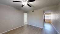 Located at 615 S Hardy Dr in Tempe, Arizona, this 2-bedroom, 1-bathroom single-story home offers a practical and well-appointed layout. The interior features light wood-style flooring throughout, painted brick accent walls that add texture and character to multiple rooms, and textured ceilings with ceiling fans in each main living space for year-round comfort.

The combined kitchen and living area serves as the heart of the home. The kitchen is outfitted with white shaker cabinetry, a white subway tile backsplash, and a full suite of stainless steel appliances including a dishwasher, electric range, and over-the-range microwave, complemented by a black refrigerator. A window provides natural light to the kitchen and dining area.

Both bedrooms are comfortably sized, each featuring the same wood-style flooring, painted brick accent walls, ceiling fans with lighting, and windows fitted with horizontal blinds that let in natural light while maintaining privacy. The primary bedroom includes a closet for added storage.

The bathroom is clean and bright, featuring a modern vanity with a white countertop and wood-toned cabinetry, a full tub-shower combination with white tile surround, and wood-style flooring that ties the space together cohesively. A hallway connects the bedrooms and bathroom, completing the efficient single-floor layout.