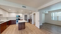 Located at 1195 Vintage Ln in Morgan Hill, California, this modern two-story home offers a thoughtfully designed layout with clean lines and contemporary finishes throughout. The open-concept kitchen serves as the heart of the main living area, showcasing two-tone cabinetry with white upper cabinets and rich walnut-toned lower cabinets, a subway tile backsplash, and a central island with a white quartz countertop. Stainless steel appliances — including a gas range, built-in microwave, and French door refrigerator — complete the space. A dedicated walk-in pantry provides generous storage directly off the kitchen. Light wood-tone vinyl plank flooring flows seamlessly throughout the main living areas, complementing the bright, neutral color palette. The bedrooms are well-sized with light-filled windows offering neighborhood views, and include walk-in closet space with built-in shelving and hanging rods. The bathroom features a walnut-toned vanity with a quartz countertop, an undermount sink, and a separate tub/shower combination with white tile surround. The attached garage offers substantial space for two vehicles, complete with an automatic opener and utility connections. The home's modern aesthetic, functional storage solutions, and open layout make it a practical and attractive residence in Morgan Hill.