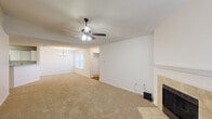 Located at 7827 N Jefferson Place Cir in Baton Rouge, Louisiana, this single-floor, 3-bedroom, 2-bathroom home offers a well-designed layout with comfortable living spaces throughout. The open-concept living and dining area serves as the heart of the home, featuring plush neutral carpeting, a ceiling fan with light fixture, a chandelier over the dining space, and a tile-surround fireplace that adds warmth and character. Natural light flows in through multiple windows fitted with blinds. The kitchen connects seamlessly to the living and dining areas via a peninsula breakfast bar, and is outfitted with white cabinetry, laminate countertops, and hardwood-style flooring. The spacious primary bedroom includes a ceiling fan, multiple windows, sliding glass door access to a private outdoor balcony, and a generous walk-in closet with wire shelving on multiple walls. The additional bedrooms are well-proportioned and share the same warm carpeting found throughout the main living areas. Two bathrooms serve the home, with one featuring hardwood-style flooring, a single-sink vanity, and a full soaking tub with shower. Textured ceilings are consistent throughout, lending the home a classic residential feel.