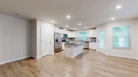 Located at 316 Glover Circle in Greenville, SC, this two-story, 3-bedroom, 4-bathroom home offers a thoughtfully designed layout spread across two floors. The main level features an open-concept kitchen and living area with warm hardwood-style flooring and abundant natural light from multiple windows with plantation blinds. The kitchen is a standout, showcasing white shaker cabinets, gray quartz countertops, a subway tile backsplash, stainless steel appliances including a range, microwave, and dishwasher, and a central island that adds extra prep and storage space. The living area flows naturally from the kitchen and benefits from the staircase's architectural presence. An attached garage with a standard roll-up door provides convenient parking and storage. The upper floor houses all three bedrooms, including a spacious primary bedroom, each carpeted for comfort and featuring windows with exterior views. Four clean, well-appointed bathrooms include tub-shower combinations and wood-look flooring. Neutral tones throughout — soft beige walls, white trim, and light flooring — create a consistent, move-in-ready aesthetic. A hallway and closet complete the layout, making this home a practical and comfortable residence in the Greenville area.