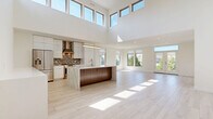 Located at 28790 Addison Court in Pepper Pike, Ohio, this modern single-floor home offers 3 bedrooms, 2 bathrooms, a laundry room, and a dedicated closet. The open-concept design immediately impresses with a dramatic two-story great room featuring soaring ceilings lined with clerestory windows, flooding the space with abundant natural light. Light-toned hardwood-style flooring flows seamlessly throughout the main living areas, enhancing the airy, contemporary feel.

The chef's kitchen is a standout, showcasing high-gloss white cabinetry reaching to the ceiling, a striking marble-veined waterfall island, stainless steel appliances, and a mosaic tile backsplash with a sleek range hood. The kitchen opens directly to the expansive living area, making it ideal for entertaining.

The primary bedroom is generously sized and served by a spa-inspired en suite bathroom complete with a soaking tub, glass-enclosed shower, dual-sink white vanity with illuminated mirrors, and elegant tile flooring. Additional bedrooms feature plush carpeting and large windows with neighborhood views. The well-appointed laundry room includes a side-by-side washer and dryer, built-in cabinetry, countertop workspace, and ample wire shelving for storage.